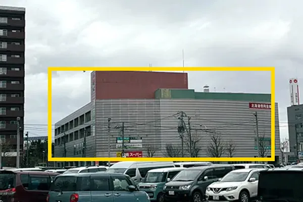 地上に出ると、右手に駐車場・駐輪場があります。奥に見えるのが七彩館ビルになります。