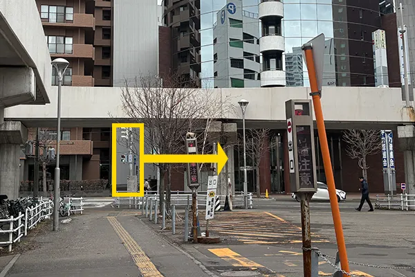 駐車場横の歩道を直進し、横断歩道を渡ります。渡った後は矢印の方向へ。